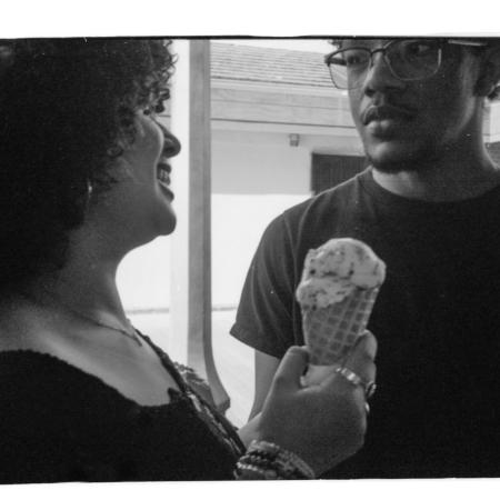 black and white photo: aj and zach sharing an ice cream
