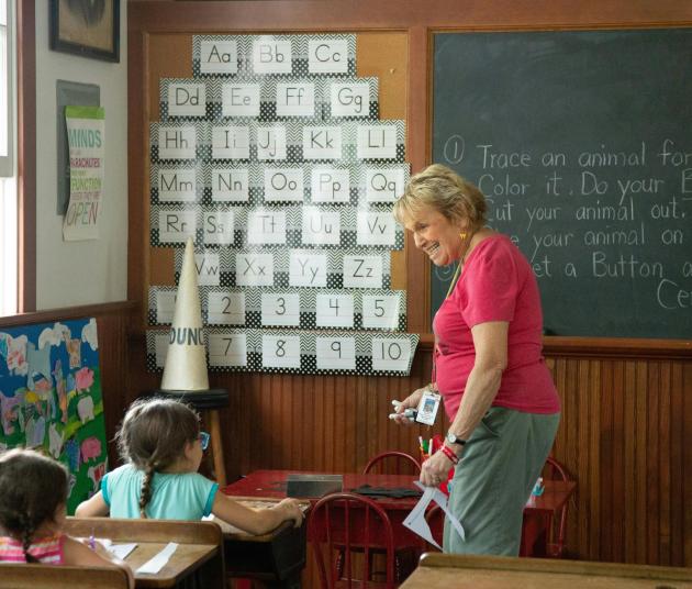 teacher smiling at student to the left